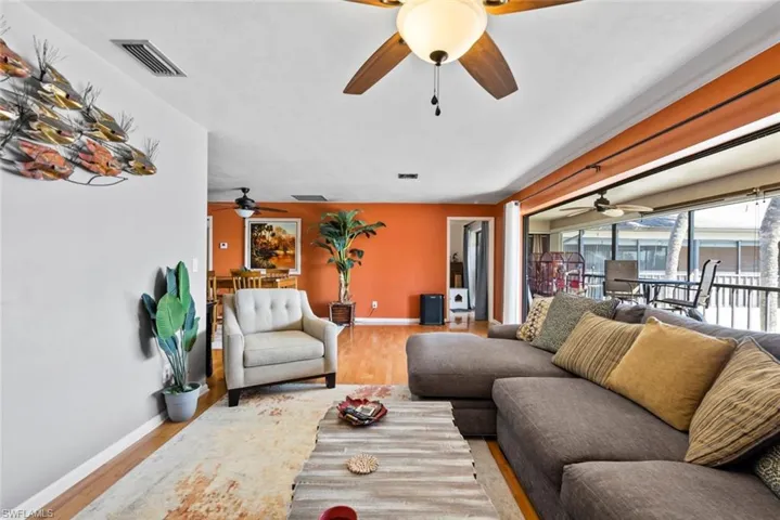 Living area with baseboards, visible vents, and wood finished floors