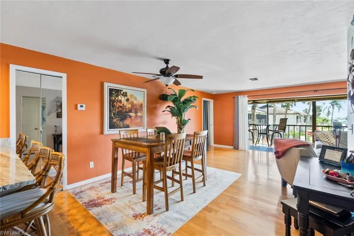 Dining space featuring light wood finished floors, a ceiling fan, and baseboards