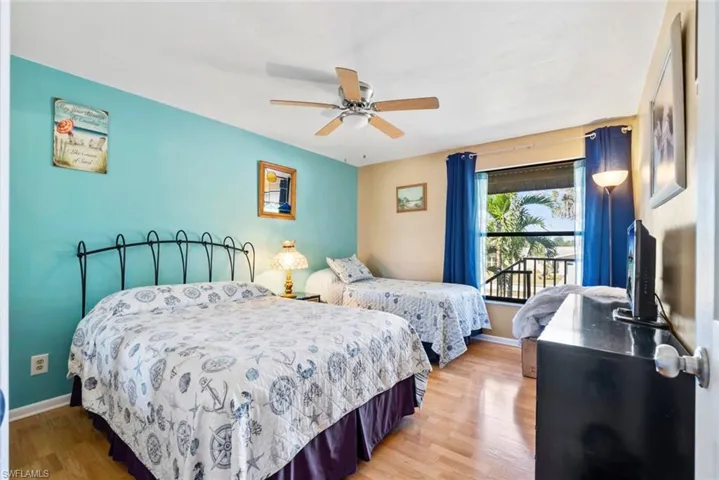 Bedroom featuring light wood-style floors, baseboards, and a ceiling fan