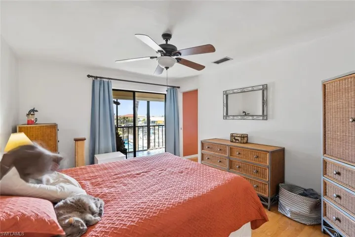Bedroom with access to outside, light wood-type flooring, visible vents, and a ceiling fan