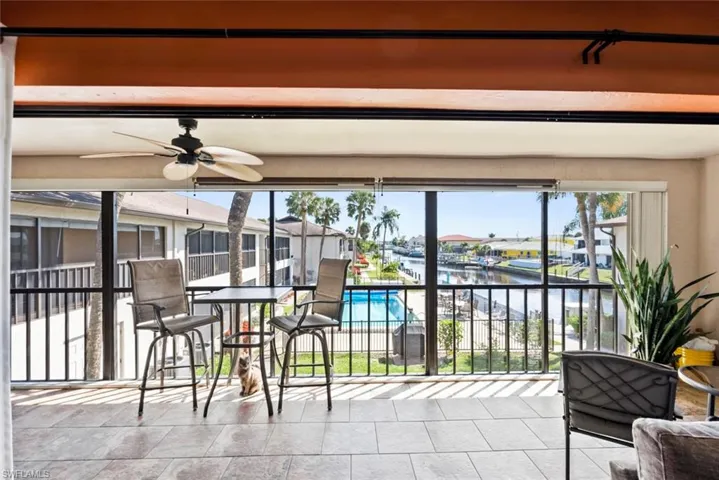 Sunroom featuring a ceiling fan and a water view