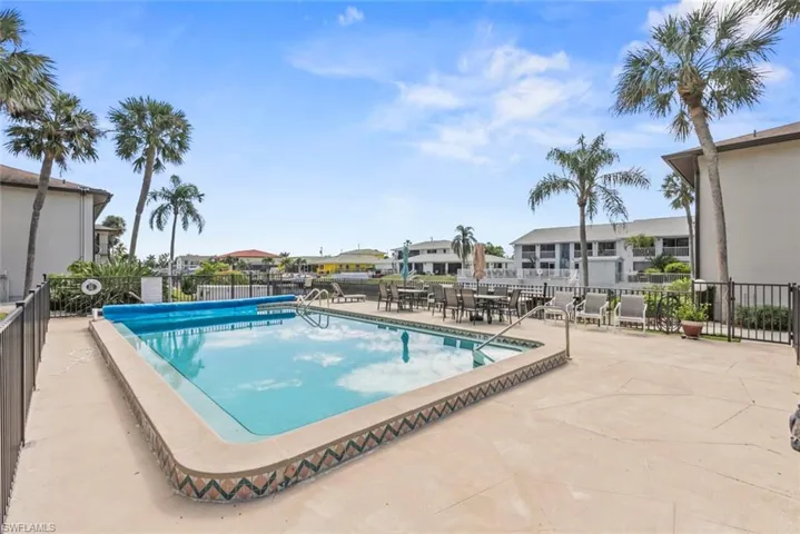 View of pool with a patio and fence