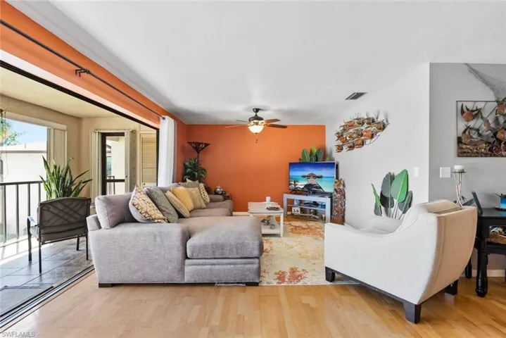 Living area featuring ceiling fan, light wood-type flooring, and visible vents