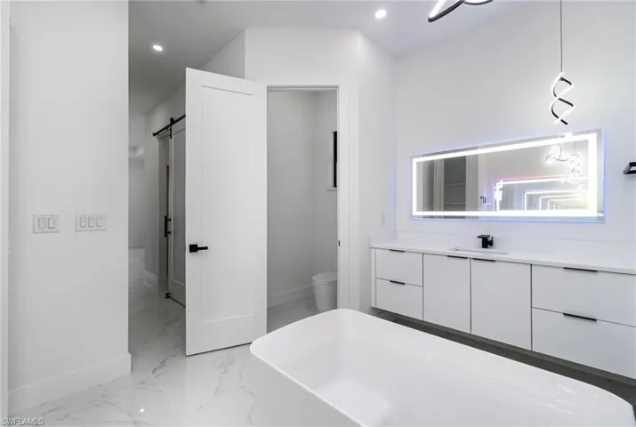 Bathroom with vanity, toilet, and a bath