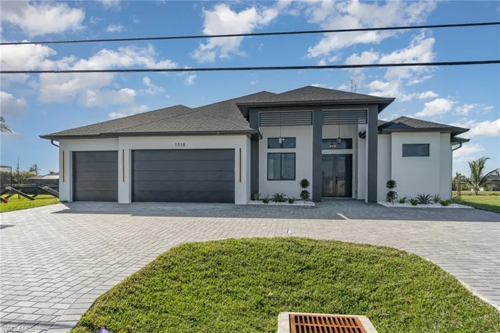 View of front of property featuring a front yard and a garage