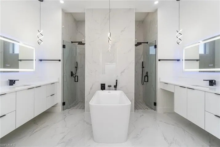 Bathroom with vanity, a wealth of natural light, and shower with separate bathtub