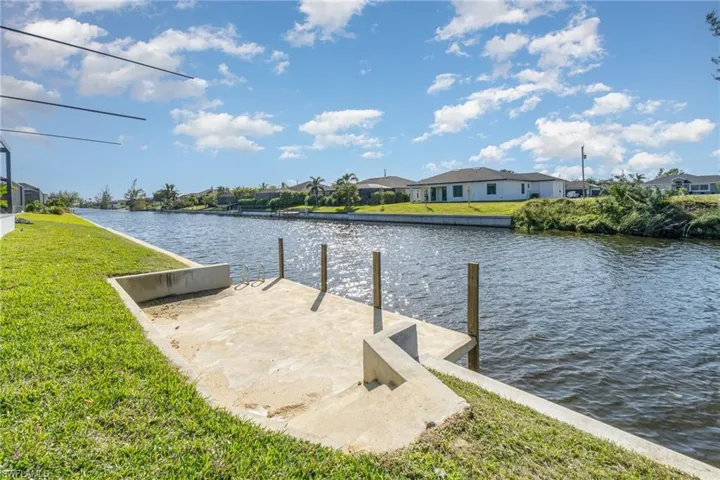 Dock area with a water view and a lawn