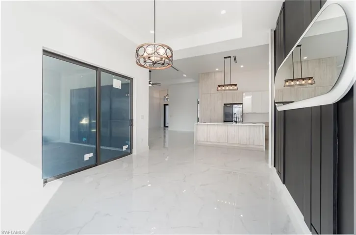 Hallway featuring an inviting chandelier and a tray ceiling