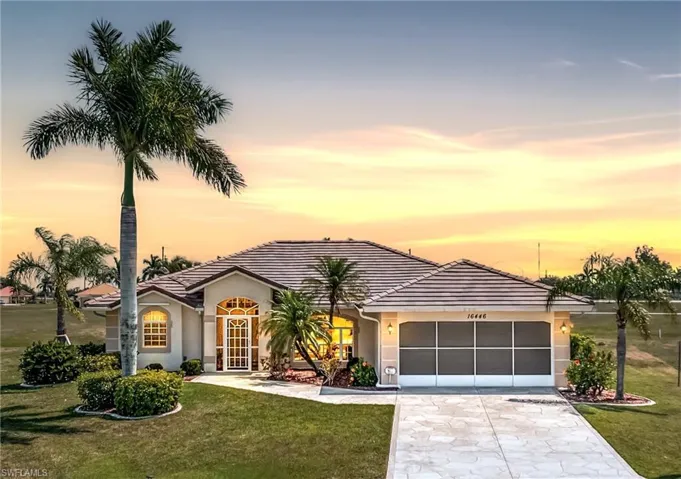 View of front facade with a front lawn, concrete driveway, a tiled roof, and stucco siding