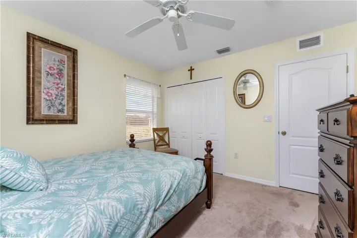 Bedroom featuring ceiling fan, a closet, and light colored carpet