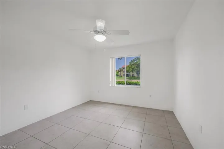 Unfurnished room featuring light tile patterned floors and a ceiling fan