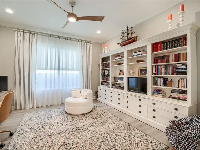Living area with light hardwood / wood-style floors, ornamental molding, and ceiling fan