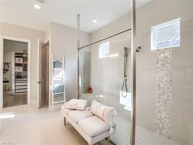 Bathroom featuring tiled shower and tile patterned floors