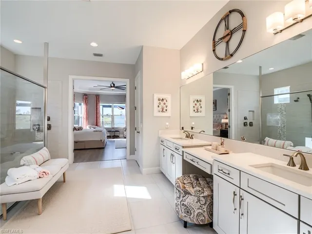 Bathroom with vanity, tile patterned floors, ceiling fan, and walk in shower