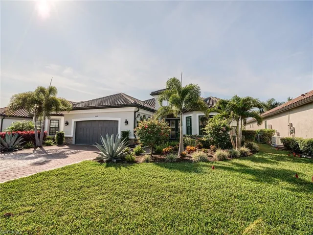 Mediterranean / spanish house featuring a front lawn and a garage