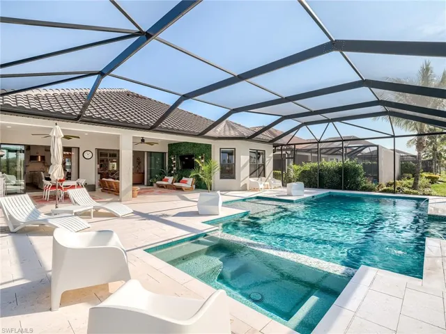 View of swimming pool with an in ground hot tub, a patio, glass enclosure, and ceiling fan
