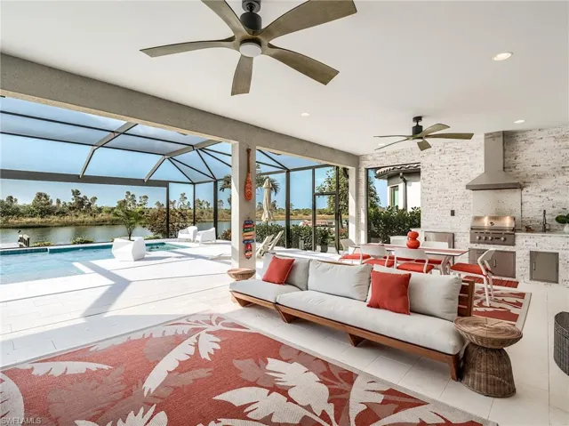 Sunroom with sink, a water view, and ceiling fan