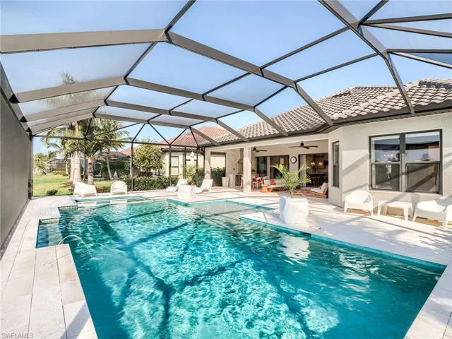 View of pool with a patio area, pool water feature, glass enclosure, and ceiling fan