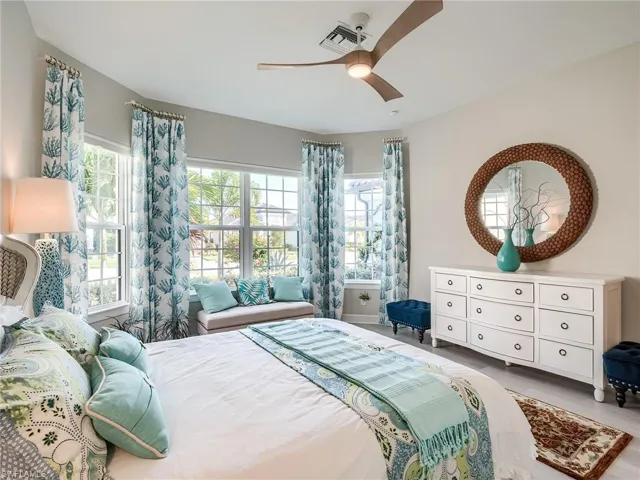 Bedroom with ceiling fan, multiple windows, and hardwood / wood-style floors