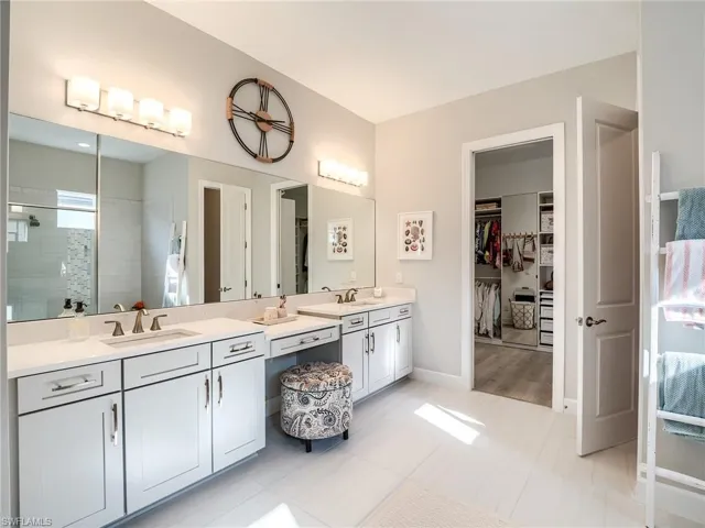 Bathroom featuring a tile shower, tile patterned floors, and vanity