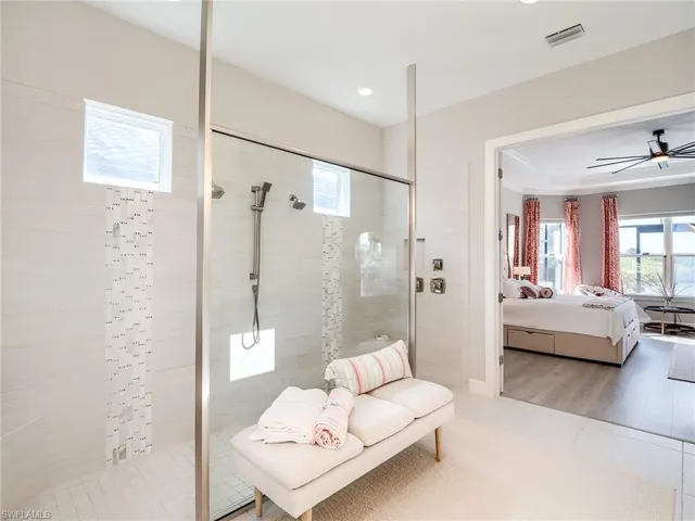 Bathroom with a tile shower, hardwood / wood-style floors, and a healthy amount of sunlight