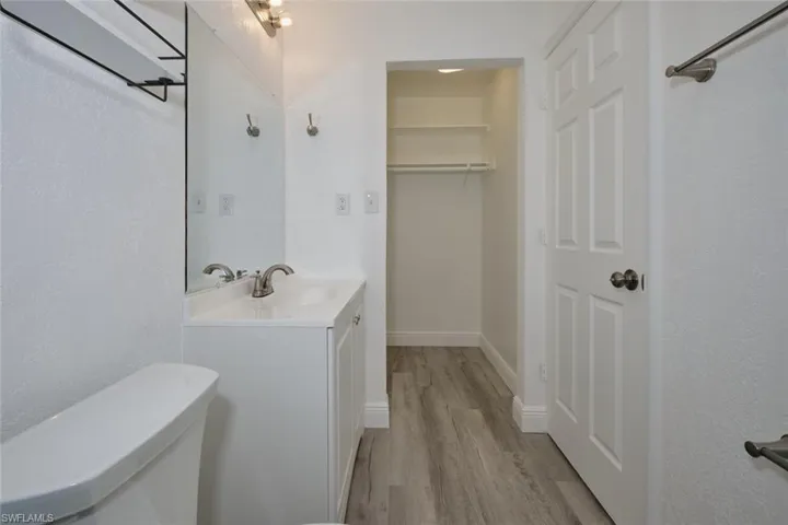 Bathroom featuring vanity, hardwood / wood-style floors, and toilet