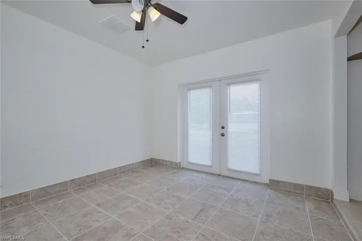 Unfurnished room featuring ceiling fan and french doors