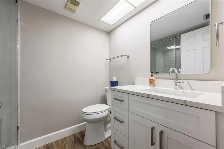 Bathroom featuring vanity, wood finished floors, and tiled shower