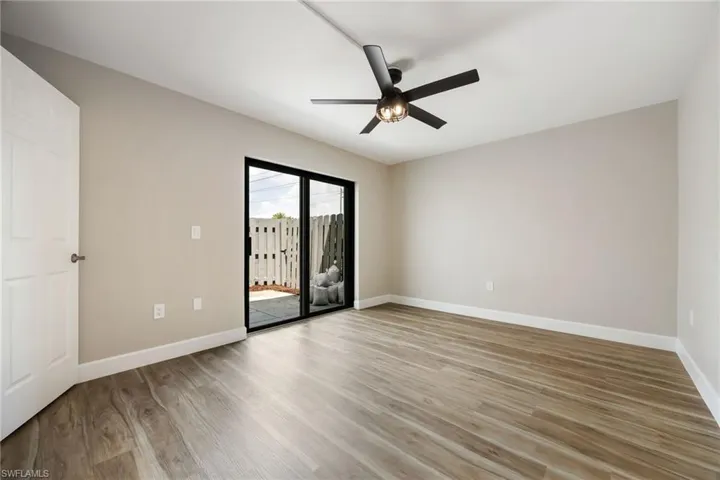 Unfurnished room with wood finished floors and a ceiling fan
