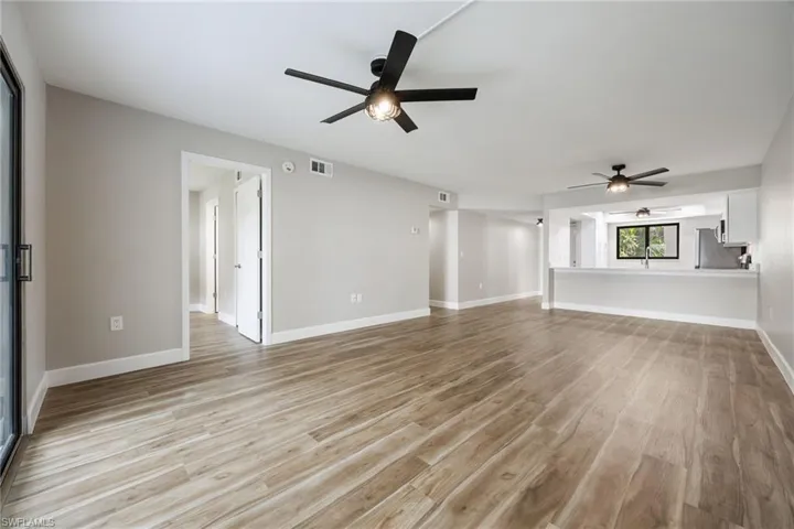 Unfurnished living room with light wood finished floors and ceiling fan