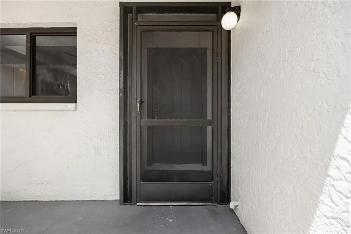 Doorway to property with stucco siding