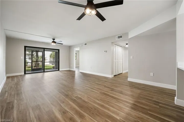 Unfurnished living room featuring wood finished floors and ceiling fan