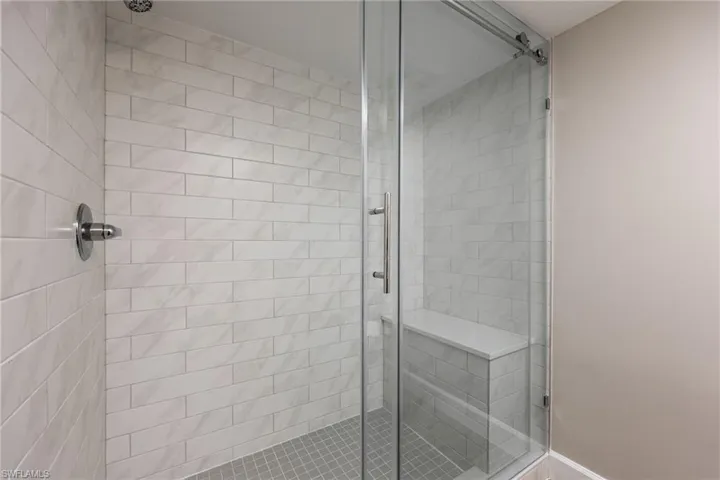 Bathroom featuring a shower stall and baseboards