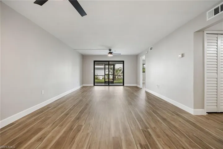 Unfurnished living room with wood finished floors and ceiling fan