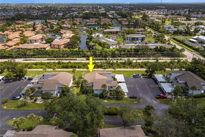 Aerial view of property and surrounding area featuring nearby suburban area and a large body of water
