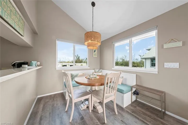 Dining area featuring a wealth of natural light, breakfast area, dark hardwood / wood-style flooring, and lofted ceiling