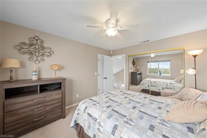 Bedroom featuring ceiling fan, a closet, and light carpet