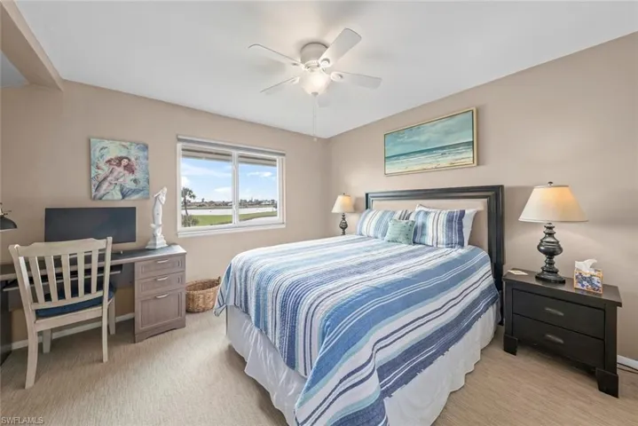 Bedroom with light colored carpet and ceiling fan