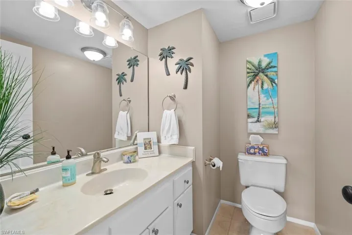 Bathroom featuring toilet, vanity, and tile patterned flooring