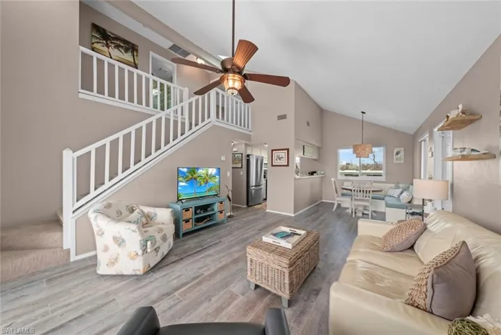 Living room featuring ceiling fan, high vaulted ceiling, and hardwood / wood-style floors