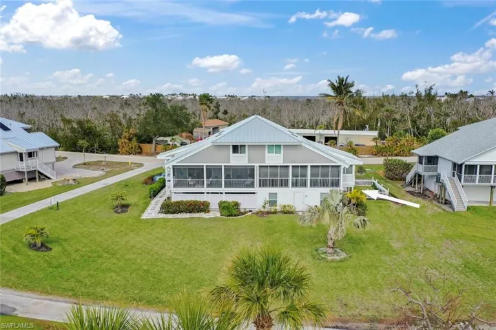 Rear view of property featuring a yard and a sunroom