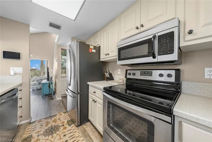 Kitchen featuring white cabinets, light hardwood / wood-style flooring, and stainless steel appliances