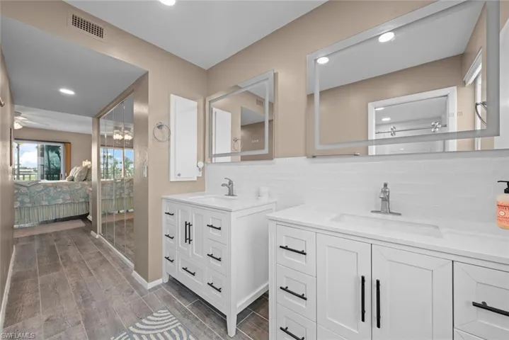 Bathroom featuring ceiling fan, vanity, and tasteful backsplash