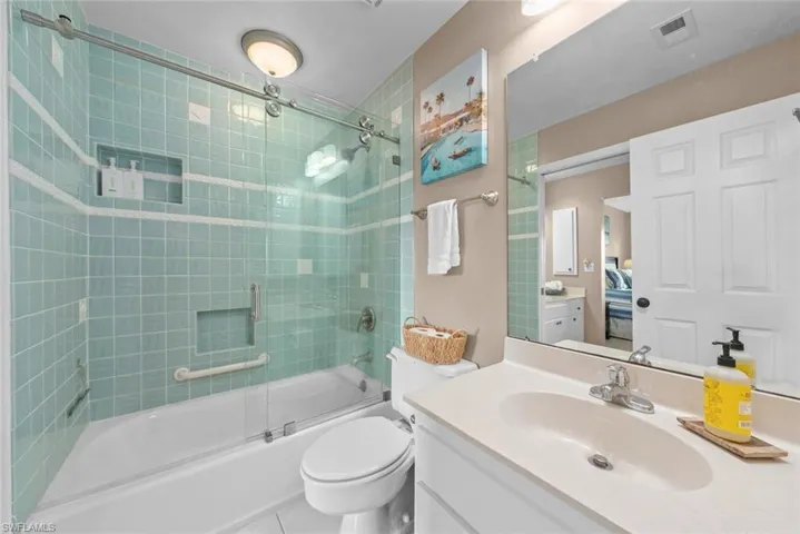 Full bathroom with combined bath / shower with glass door, toilet, tile patterned flooring, and vanity