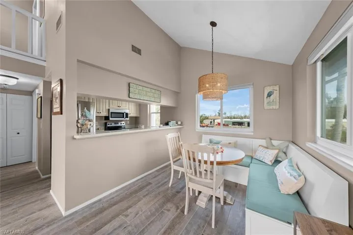 Dining area featuring breakfast area, high vaulted ceiling, and light hardwood / wood-style floors