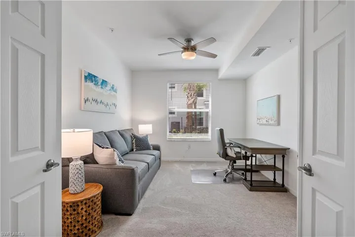 Office space with light carpet and a ceiling fan