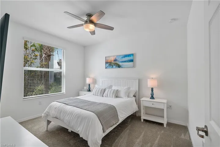 Carpeted bedroom with baseboards and a ceiling fan