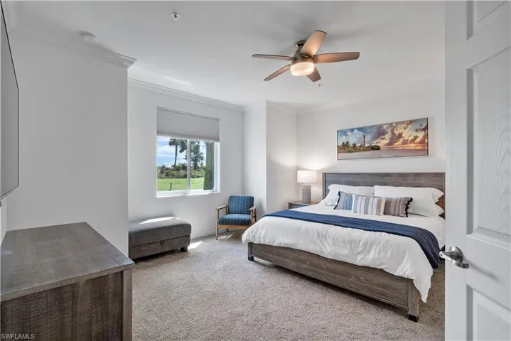 Carpeted bedroom featuring crown molding and ceiling fan