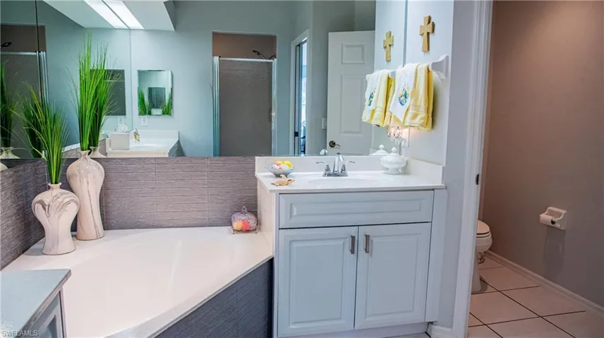 Full bath with vanity, light tile patterned Bathroom with shower and the tub