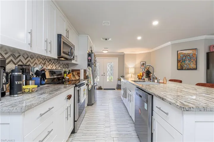 Kitchen featuring tasteful backsplash, visible vents, appliances with stainless steel finishes